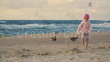 两个<strong>可爱</strong>的小女孩在沙滩上跑着喂<strong>鸭子</strong>