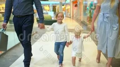 快乐的四口之家在购物。 在<strong>商场</strong>里的家人。 孩子们在购物<strong>中</strong>心和父母在一起。 家庭购物在大商店。 二.