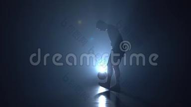 足球自由球员填充球与蓝色聚光灯的剪影。 慢动作