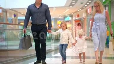 快乐的四口之家在购物。 在<strong>商场</strong>里的家人。 孩子们在购物<strong>中</strong>心和父母在一起。 家庭购物在大商店。 二.
