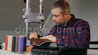 手工制作皮夹的过程.. 人在皮革上做冲压。 做自己的生意。 手工制作。