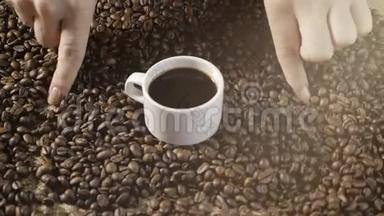 咖啡杯和咖啡豆。 女人`手牵着一颗咖啡豆的心。 一杯白咖啡加烤