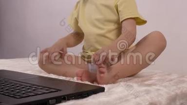 一个小孩按下笔记本电脑键盘、特写、婴儿和电脑上的按钮