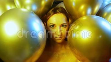 特写女孩脸上金色的亮片放在金色气球里