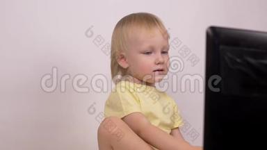 白种人小女孩金发碧眼地看着电脑笔记本电脑的<strong>笑声</strong>和鬼脸，特写，情绪