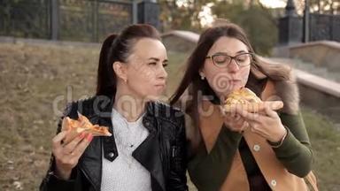 两个女孩坐在公园里，吃着美味的大<strong>披萨</strong>，里面有<strong>鸡肉</strong>和蘑菇