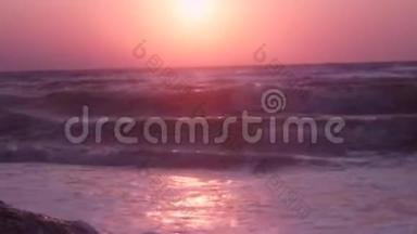 海浪，泡沫，海浪，在潮湿的沙滩上，黑暗的大海，在橙色日落的背景下