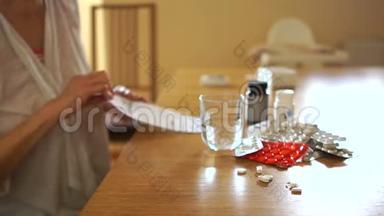 一个女人`手的肖像。 看着菜谱，吃了药丸，用玻璃杯里的水把它们挤出来
