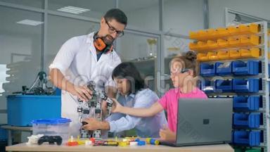 学校科学教师与聪明的学生一起<strong>学习机</strong>器人技术。