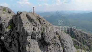 一个年轻的女人站在一个令人印象深刻的<strong>山崖</strong>边缘，杜莉变焦