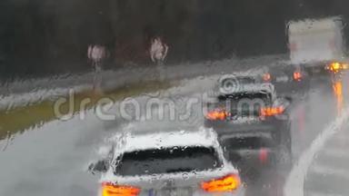 雨中公路交通堵塞的景象。 汽车连续行驶。 雨点般的落在窗户上，一道道道痕
