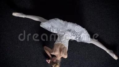 年轻女孩芭蕾舞演员的剪影坐在地板上，伸展在<strong>劈叉</strong>上，芭蕾概念，顶级镜头