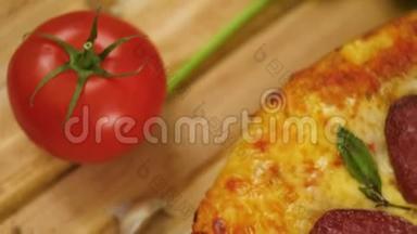 热培罗尼比萨躺在木盘上，上面装饰着罗勒绿、番茄和大蒜，动作缓慢，靠近顶部