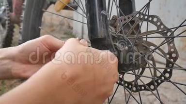 那个女孩打破了自行车的轮子。 自行车修理。 骑自行车的人正在修理自行车。 在轮子上打洞。