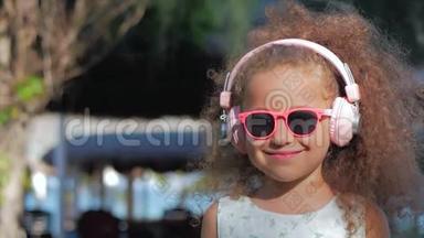 一个可爱的孩子的肖像，一个穿着<strong>粉色</strong>眼镜和<strong>粉色</strong>耳机的白色裙子的美丽的小女孩