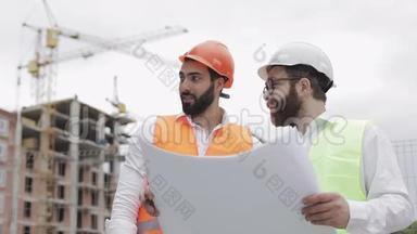高层建筑施工现场或建筑工地，男建筑工程师与建筑师讨论.. 他们