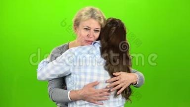 土著拥抱，他们站着说话。 妈妈拥抱她的女儿。 绿色屏幕