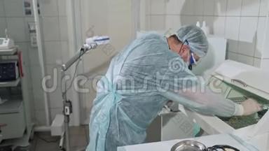 有趣的视频，一名外科医生从消毒设备中取出<strong>医疗<strong>器</strong>械</strong>，手里攥着一个夹子