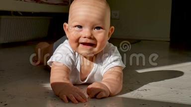 可爱的六个月大的宝宝正躺在地上开心地笑着.. 孩子敲着地板上的一条小溪，使劲地