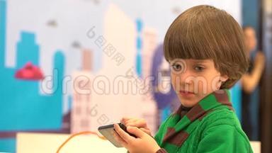 可爱的小男孩使用智能手机。 机器人在第四<strong>届</strong>俄罗斯科<strong>学</strong>节为孩子们演示。 活动的目的是