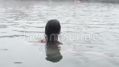 地热温泉。 女人在温泉池里放松。 女孩享受沐浴在温暖的矿泉水30fps的露天盆地