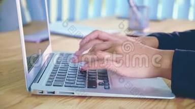 在办公室背景下的笔记本电脑上工作的人手。 办公室里的一位年轻妇女在键盘上拨文件。