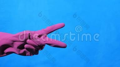 干净的手在蓝色背景上的紫色橡胶手套。 剪刀手。