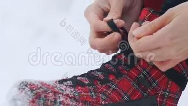 冬季。 一个女人坐下来，开始把鞋带系在鲜红的溜冰鞋上