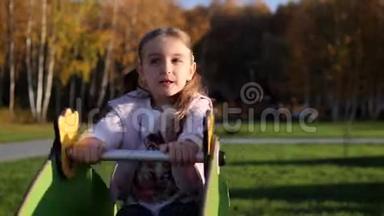 小可爱的女孩在公园的操场上荡秋千玩乐