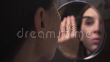 美丽的女孩照镜子，用铅笔画眉毛，化妆。