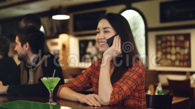 年轻的<strong>女人</strong>正在用手机<strong>说话</strong>，而坐在酒吧的柜台<strong>说话</strong>。 顾客搬进来<strong>说话</strong>
