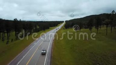 夏季多云间阴天，绿林丘陵之间的公路公路上，无人机低飞，<strong>车水马龙</strong>。