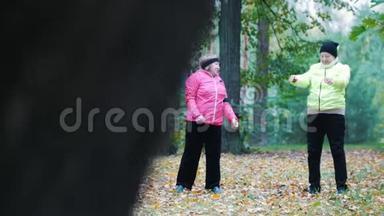 穿着夹克的成熟女人在斯堪的纳维亚人<strong>散步</strong>后的秋天<strong>公园里</strong>做体操