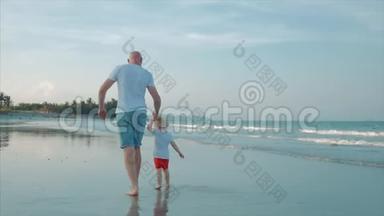 幸福的父子在日落时在海滩上玩和玩。 动作缓慢。 幸福家庭童年