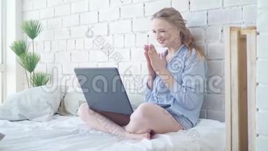 年轻开朗的女人坐在床上，通过笔记本电脑<strong>发信息</strong>