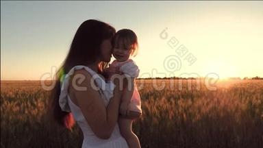 小宝宝和妈妈一起去麦田，在金色夕阳的背景下欢笑.. 慢动作。