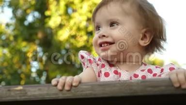 小快乐的宝宝微笑着，第一颗牙齿在公园的博克背景下玩耍