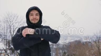 布吕内特年轻人在冬季雪景公园的黑色引擎盖画像。 慢动作。 <strong>城市</strong>城镇<strong>背景图</strong>