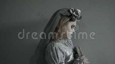 一个穿着一个死去的新娘的服装的少女，化妆着一张脸，手里拿着一个女巫`她<strong>摔倒了</strong>。 经过，离开