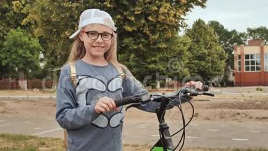 夏天，金发小女孩在城里骑着自行车摆姿势。