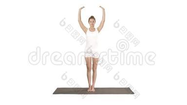 漂亮的女孩站在平衡瑜伽姿势Garudasana年轻女子在鹰瑜伽姿势的白色背景。