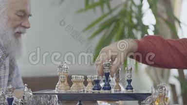 两个成熟的老朋友坐在家里下棋。高加索老人邻居在室内愉快地下棋