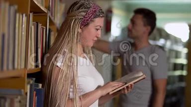美丽的女孩正在图书馆<strong>翻阅</strong>一本书