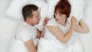 在<strong>喧闹</strong>的夜晚，打鼾的男人哽咽着大声叫醒他的妻子，她用枕头闭上耳朵。 上文视