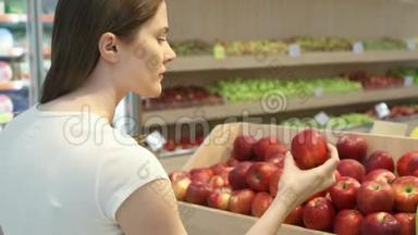 年轻女子在杂货店买健康食品。 素食女孩选择新鲜的红<strong>苹果</strong>