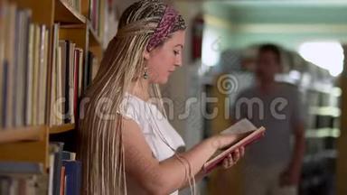 美丽的女孩正在图书馆<strong>翻阅</strong>一本书