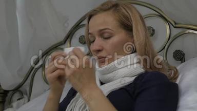一个生病的女人躺在床上，脖子上围着一条温暖的围巾，在<strong>感冒</strong>或<strong>感冒</strong>时吹鼻涕