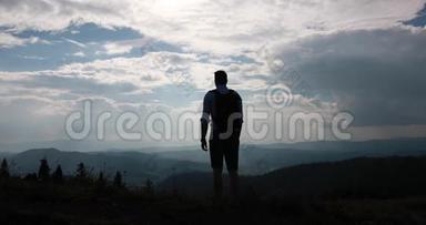 孤独地走在山里。 从后面看，一个背着背包的人站在美丽的山景和
