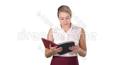 女人拿着，打开书或笔记本，在白色的背景上大声朗读一些东西。