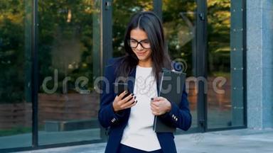 有智能手机的女商人。 学生女孩用手机。 戴眼镜的美女在手机上上网